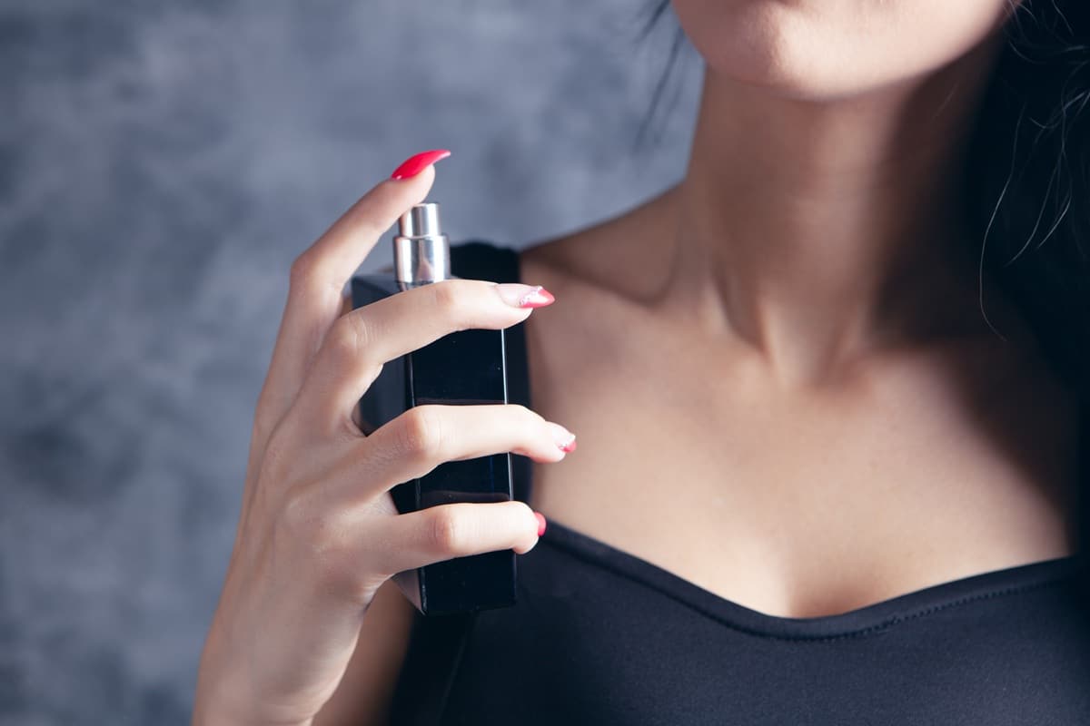 femme met du parfum