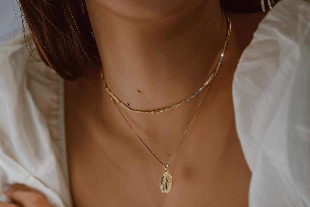 collier avec médaille miraculeuse au cou d'une femme