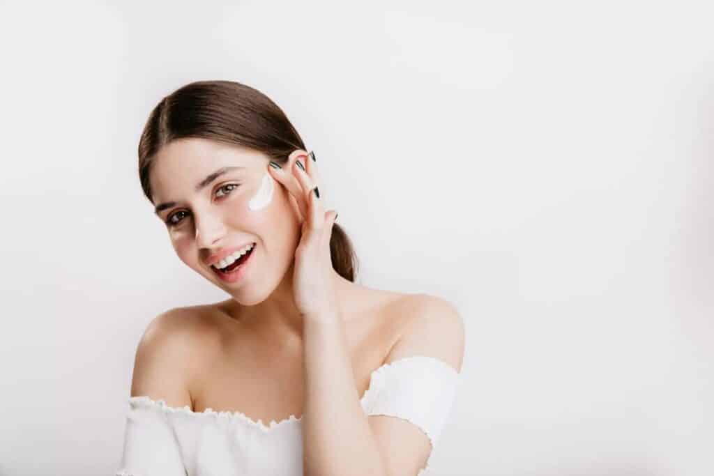 femme posant de la crème sur son visage